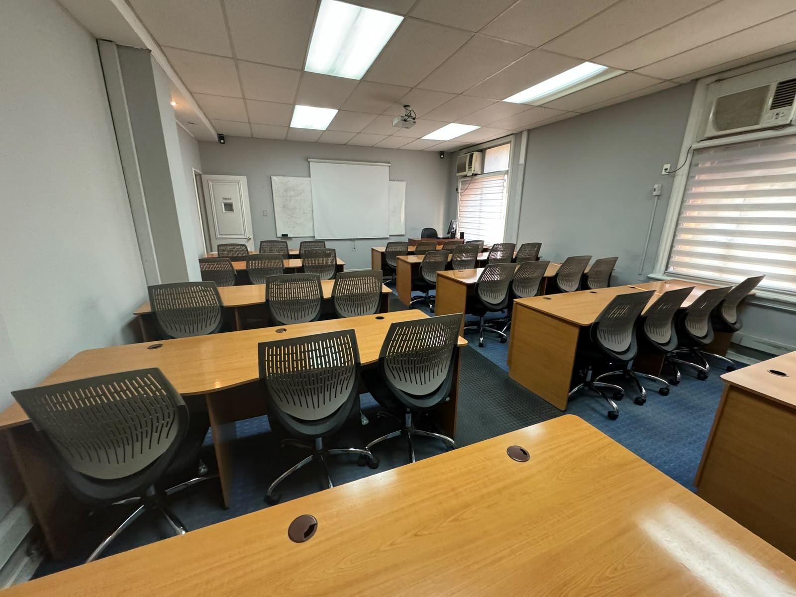 Sala de clases de Comander con mesas y asientos